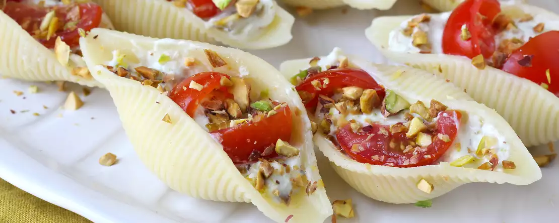 Conchiglioni umpluți, serviți reci, cu stracciatella, fistic, roșii cherry și lămâie
